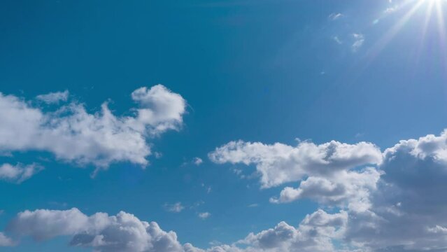 heavenly sky cloudscape natural background. timelapse of blue sky majestic sun bright sunlight air. sun travels through fluffy clouds makes beautiful rays and sunbeams over blue sky. landscape footage