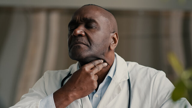 African ethnic doctor medical worker rub sore throat suffer from inflamed tonsils unhealthy mature man hurt swallow has covid-19 disease symptom coronavirus infection contagion virus health problem