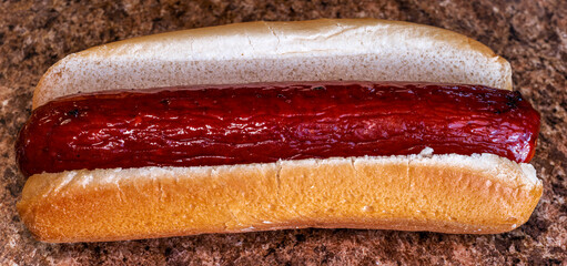 Air fried hot dog on a bun with no condiments up close