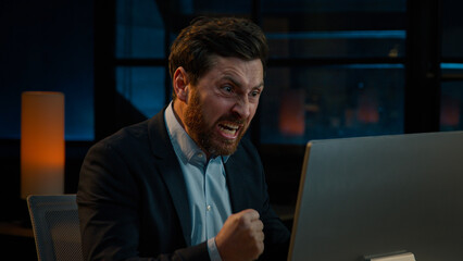 Annoyed angry businessman Caucasian middle-aged 40s man CEO employee mad furious crazy shouting fail online business project on computer trouble failure problem stress evening night office background