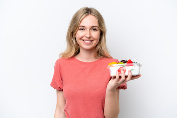 Young English woman holding a bowl of fruit over isolated white background smiling a lot