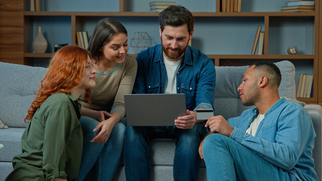 Excited team diverse men women use credit card for online payment on laptop multiethnic group of business people friends colleagues winners celebrate success earn money win victory discounts cashback