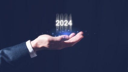 2024 business planning and strategy concept, businessman holding virtual icon of the year 2024, marketing financial and research analysis, investment trends next new year