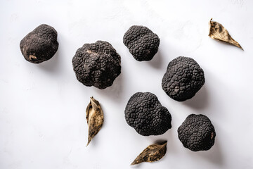 Black truffle gourmet mushrooms on white stone background, top view flat lay. Generative AI - obrazy, fototapety, plakaty