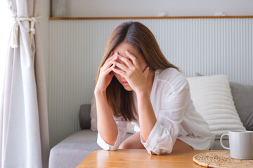 A young woman feeling sad and stressed, sick and headache at home