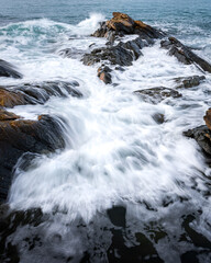 Big waves break on the rocky shore.