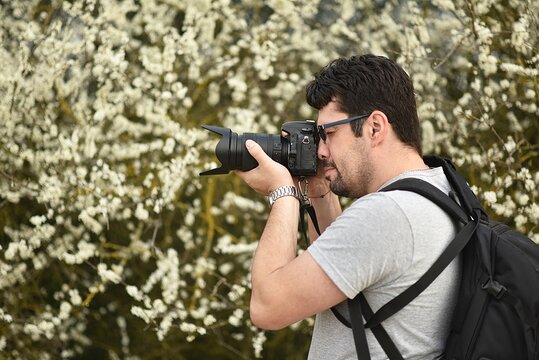 a man photographs spring flowers