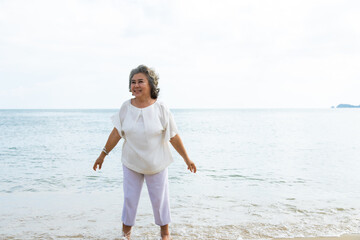Fototapeta na wymiar happy elderly woman doing exercise on beach.