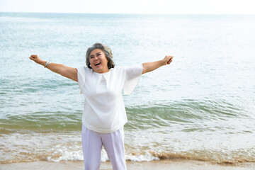 Fototapeta na wymiar happy elderly woman doing exercise on beach.