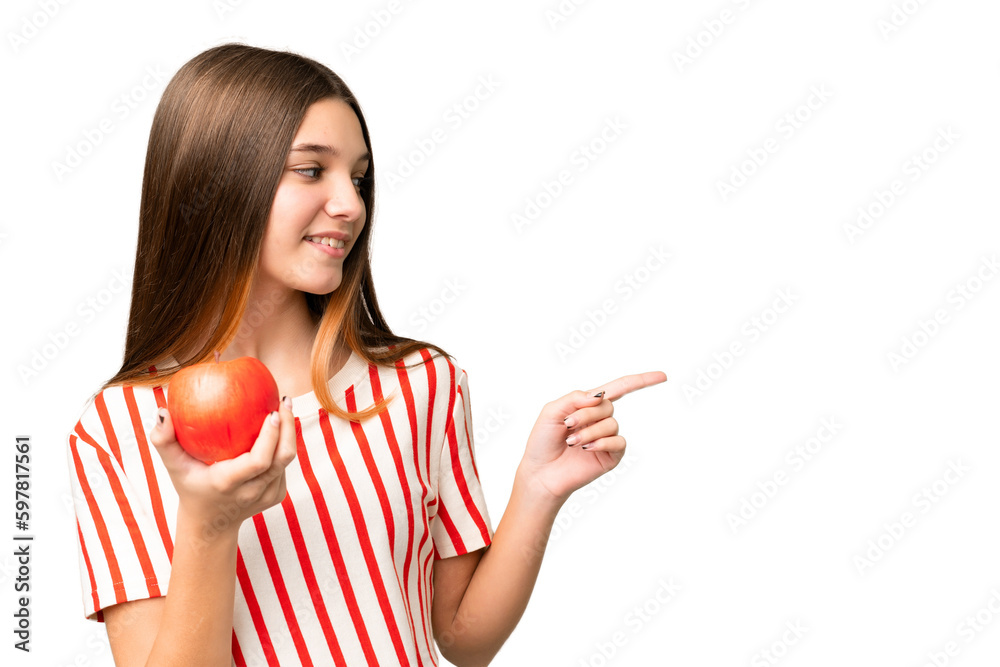 Sticker Teenager girl with an apple over isolated chroma key background pointing to the side to present a product