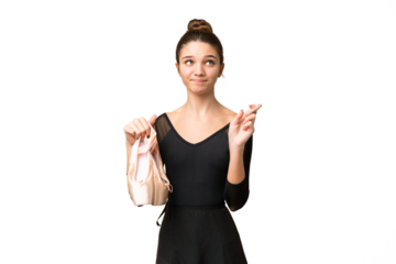 Teenager girl practicing ballet over isolated chroma key background with fingers crossing and wishing the best