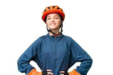 Teenager cyclist girl over isolated chroma key background posing with arms at hip and smiling