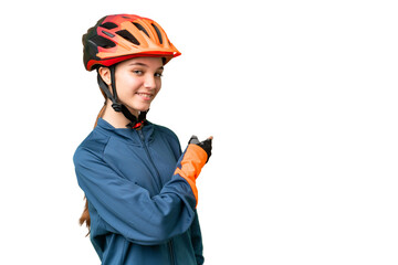 Teenager cyclist girl over isolated chroma key background pointing back