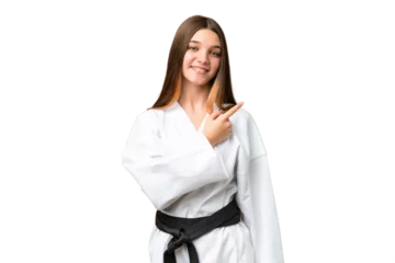 Tischdecke Teenager girl doing karate over isolated chroma key background pointing to the side to present a product © luismolinero