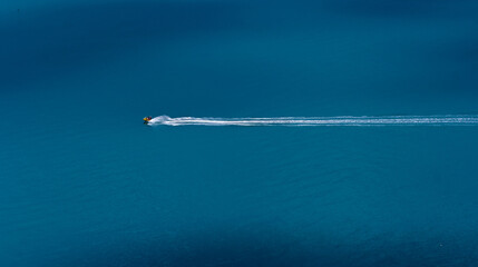 A trace from a jet ski at sea. Two men are riding during a summer vacation on a hot sunny day. View...
