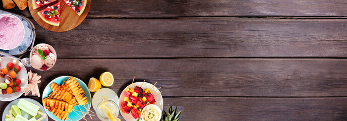 Fototapeta na wymiar Refreshing summer food corner border. Variety of grilled fruits, ice cream and ice pops. Top view on a dark wood banner background.