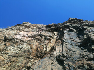 Cracked rock texture.. brown rock texture with cracks. Close-up. Rough mountain surface. Stone granite background. rock wall backdrop with rough texture. Abstract, grungy and textured surface