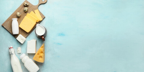 Different dairy products on light blue background with space for text