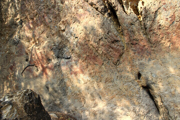Ancient stone walls, brown and very old, with painted patterns on the surface.