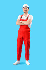Male carpenter in hardhat on blue background