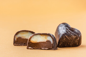 Set of homemade brown chocolate bonbons slice. Assortment of hand painted candies. Candy cut in a half. Mockup with a copy space. Macro shot of  chocolatier products on beige background