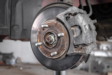 Brake pad on a car disc close-up. Car brake. Disassembled wheel. Disc without tire. Transport topic. Garage background. Replacing the brake box. Auto mechanic work.