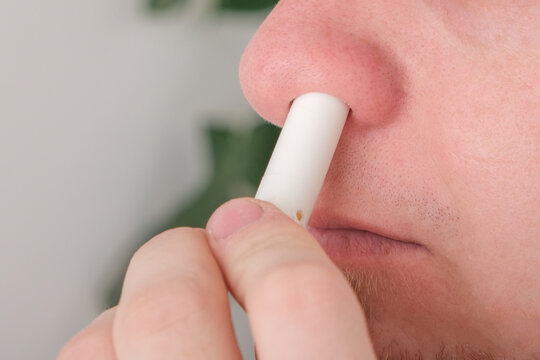 Adult man uses nasal stick inhaler to smell for relieve dizzy and faint symptoms. Concept health problem, sickness and remedy. Increases freshness, reduces dizziness and stuffy nose. self take care.