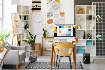 Fototapeta premium Interior of office with graphic designer's workplace and sofa