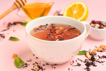 Cup of fruit tea on pink background, closeup