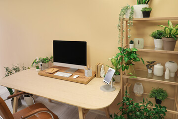 Interior of office with workplace, shelving unit and houseplants