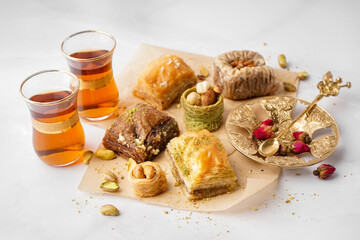 Tasty baklava and glasses of Turkish tea on light background