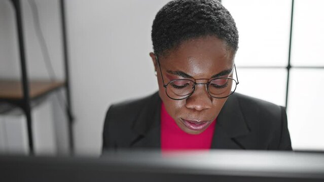 African american woman business worker using computer eating apple at office