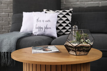 Coffee table with florarium and magazine in modern living room