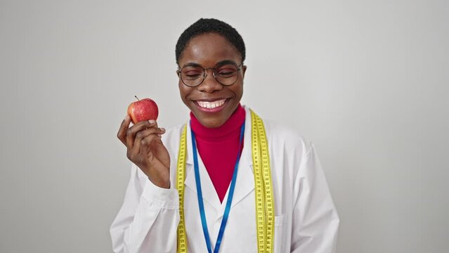 African american woman dietician smiling confident holding apple over isolated white background