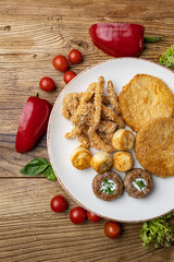 A plate of fried meats with a fried chicken and fried potato.