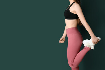 Sporty young woman in leggings on green background - obrazy, fototapety, plakaty