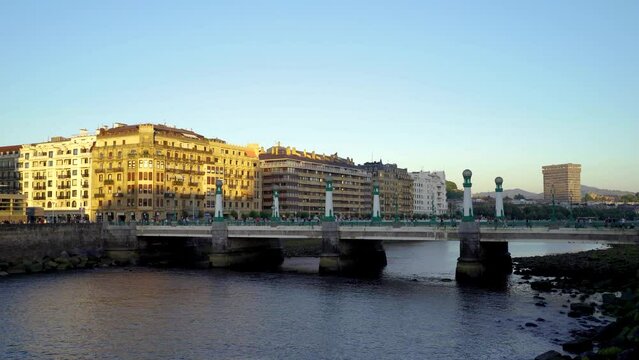 San Sebastian, SPAIN - July 09 2022. View of Kursaal zubia Bridge, in the old city center of the town. Sunset colours. People and cars passing on the bridge. Stabilized static video.