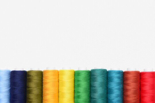 Set of colorful sewing threads on light background, closeup