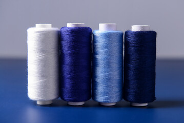 Set of different thread spools on blue background