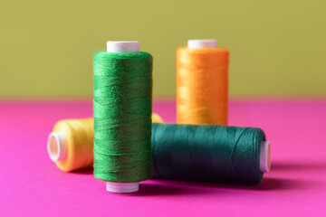 Set of different sewing threads on color table