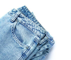 Folded jeans on white background, closeup