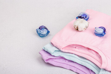Eco friendly spring closet cleaning, capsules for machine washing. Pastel T-shirts, sale concept
