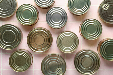 Many tin cans with fish on pink tiled table