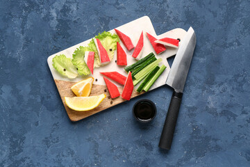 Board with tasty crab sticks and sauce on blue background © Pixel-Shot