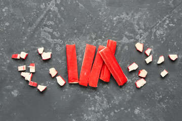 Tasty cut and whole crab sticks on green background © Pixel-Shot