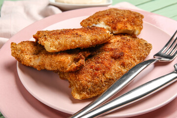 Plates of tasty fried codfish on table, closeup