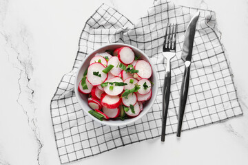 Bowl with fresh slices of radish on marble background
