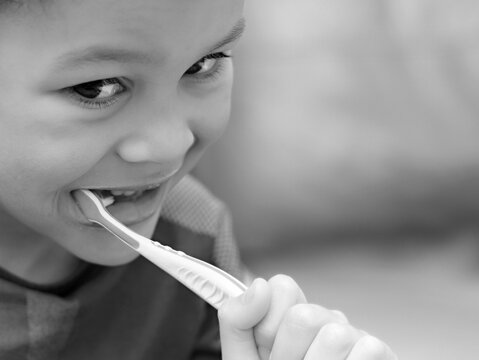little boy brushing his teeth with an electric tooth brush stock image with background with people stock photo  