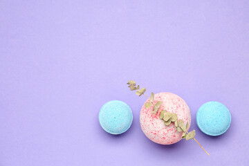 Bath bombs with eucalyptus branch on lilac background