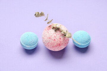 Bath bombs with eucalyptus branch on lilac background